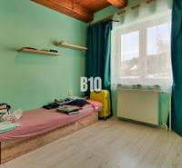 Praktický 8-izbový rodinný dom na Bystričke: Vhodný pre veľkú rodinu z - Izba v rodinnom dome so stenami v pastelových farbách a oknom so závesmi.