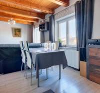 Praktický 8-izbový rodinný dom na Bystričke: Vhodný pre veľkú rodinu z - Interiér rodinného domu s podlahou s dreveným dekorom a stolom pri okne.