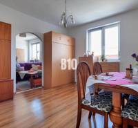 Praktický 8-izbový rodinný dom na Bystričke: Vhodný pre veľkú rodinu z - Jedáleň v rodinnom dome s nábytkom, podlahou s dreveným dekorom a stolom s kvetmi.