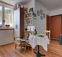 Praktický 8-izbový rodinný dom na Bystričke: Vhodný pre veľkú rodinu z - Interiér rodinného domu s podlahou s dreveným dekorom a útulným posedením pri stole.