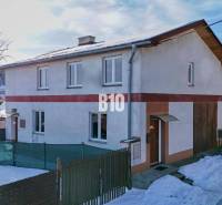 Praktický 8-izbový rodinný dom na Bystričke: Vhodný pre veľkú rodinu z - Rodinný dom v Bystričke, zimná scenéria, zasnežená cesta a plot.