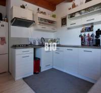 Praktický 8-izbový rodinný dom na Bystričke: Vhodný pre veľkú rodinu z - Kuchyňa v rodinnom dome so svetlými skrinkami, mikrovlnkou a kávovarom.