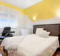 REZERVOVANÉ 4-izb. rodinný dom s garážou, Čierny Brod - Spálňa v rodinnom dome s posteľou, kreslom a podlahou s dreveným dekorom.