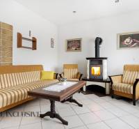 REZERVOVANÉ 4-izb. rodinný dom s garážou, Čierny Brod - Obývačka v rodinnom dome s krbom, pohovkou a dreveným stolom.