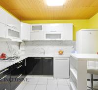 REZERVOVANÉ 4-izb. rodinný dom s garážou, Čierny Brod - Kuchyňa v rodinnom dome so svetlými skrinkami, mramorovým obkladom a bielymi spotrebičmi.