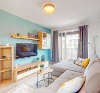 BA/PETRŽALKA-Prenájom moderného 3i bytu s parkovacím státim-Slnečnice - Obývacia izba v 3-izbovom byte s pohodlnou sedačkou a balkónom, podlaha s dreveným dekorom.