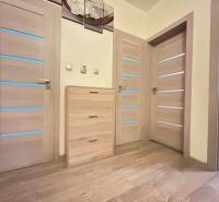 Prenájom- 2 izbovy byt- 49m2- Dadanova- Hájik  - Drevený dekor podlahy a svetlé dvere v 2-izbovom byte s jemným osvetlením.