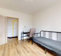 | 3-izbový byt v novostavbe, ul. Odevná + parking | Trenčín  - Izba v 3-izbovom byte s podlahou s dreveným dekorom, písacím stolom a posteľou.
