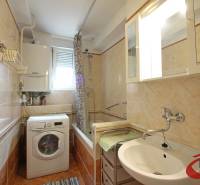 **PREDAJ 3-IZBOVÉHO BYTU S BALKÓNOM A LOGGIOU PRI SLUBEKOVEJ ZÁHRADE** - Kúpeľňa s vaňou a práčkou v 3-izbovom byte, s obkladačkami krémovej farby.