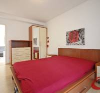 **BEZ PROVÍZIE**3-IZBOVÝ BYT S BALKÓNOM A LOGGIOU NA PALISÁDACH**      - Spálňa s podlahou s dreveným dekorom, posteľou, skrinkou a obrazom v 3-izbovom byte.