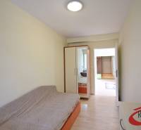 **BEZ PROVÍZIE**3-IZBOVÝ BYT S BALKÓNOM A LOGGIOU NA PALISÁDACH**      - Izba v 3-izbovom byte s pohovkou, vstavanou skriňou a podlahou s dreveným dekorom.