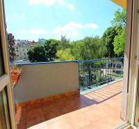 **BEZ PROVÍZIE**3-IZBOVÝ BYT S BALKÓNOM A LOGGIOU NA PALISÁDACH**      - Balkón 3-izbového bytu s výhľadom na zeleň a ďalšie budovy.