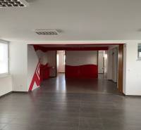 Predaj modernej administratívnej budovy v Bratislave, okres II - Priestranný interiér s červenými detailmi, vhodný pre kancelárie v modernej budove.