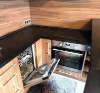 Prenajaté - 2.izbový byt s parkovaním v obci Hviezdoslavov - Kuchyňa v 1-izbovom byte so vstavanou umývačkou a dreveným dekorom.