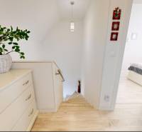 PREDANÉ - Exkluzívne na predaj rodinný dom v Stupave - Interiér rodinného domu s podlahou s dreveným dekorom a svetlým nábytkom.