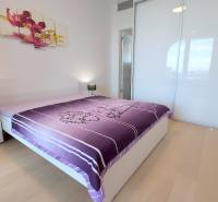 JEDINEČNÝ 2i byt, NOVOSTAVBA, KLÍMA, VÝHĽAD, PARKING, SKY PARK - Spálňa v 2-izbovom byte s podlahou s dreveným dekorom a veľkou posteľou.