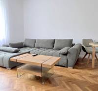 Pekný 3i byt, REKONŠTRUKCIA, KLÍMA, NIVY, Trenčianska ulica - Obývačka 3-izbového bytu ukazuje pohodlnú sedačku, stôl s kreslami na Trenčianskej ulici.