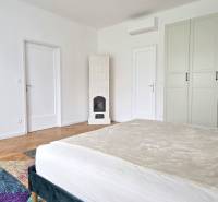 Pekný 3i byt, REKONŠTRUKCIA, KLÍMA, NIVY, Trenčianska ulica - Svetlá spálňa v 3-izbovom byte na ulici Trenčianska s parketami a bielym nábytkom.