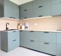 Pekný 3i byt, REKONŠTRUKCIA, KLÍMA, NIVY, Trenčianska ulica - Kuchyňa s dreveným obkladom a zelenými skrinkami na ulici Trenčianska v 3-izbovom byte.