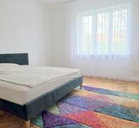 Pekný 3i byt, REKONŠTRUKCIA, KLÍMA, NIVY, Trenčianska ulica - Spálňa Trenčianska, priestranná izba, posteľ a farebný koberec. Trojizbový byt svetlý.