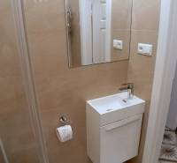 Pekný 2i byt, REKONŠTRUKCIA, CENTRUM, Bukureštská ulica, Staré Mesto - Kúpeľňa so svetlými obkladmi, umývadlo a zrkadlo na Bukurešťskej v 2-izbovom byte.