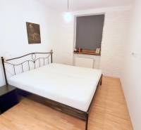 JEDINEČNÝ 2i byt, REKONŠT., 2 X .SAMOST.IZBA, Hviezdoslavovo nám.  - Spálňa s kovovou posteľou, bielymi stenami a dekoratívnymi obrazmi vedľa okna.