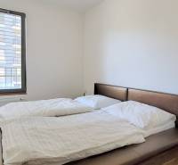 MODERNÝ 3i byt, CUBICON GARDENS, BALKÓN, PARKING, Rudolfa Mocka - Spálňa v 3-izbovom byte s pohodlnou posteľou a podlahou s dreveným dekorom.