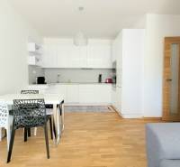 MODERNÝ 3i byt, CUBICON GARDENS, BALKÓN, PARKING, Rudolfa Mocka - Kuchyňa so stolom a stoličkami, podlaha s dreveným dekorom v 3-izbovom byte.