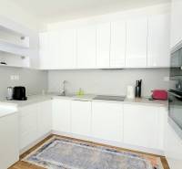 MODERNÝ 3i byt, CUBICON GARDENS, BALKÓN, PARKING, Rudolfa Mocka - Kuchyňa v 3-izbovom byte s bielymi skriňami a podlahou s dreveným dekorom.