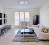 JEDINEČNÝ 2i byt, REKONŠTRUKCIA, 2 x BALKÓN, Kúpeľná ulica,Staré Mesto - Obývacia izba 2-izbového bytu s pohovkou, TV a podlahou s dreveným dekorom.