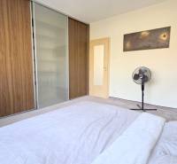 JEDINEČNÝ 2i byt, REKONŠTRUKCIA, 2 x BALKÓN, Kúpeľná ulica,Staré Mesto - Spálňa v 2-izbovom byte s veľkou vstavanou skriňou a ventilátorom na podlahe.