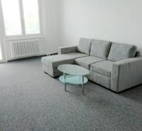 Pekný 3i byt, 3 x NEPRIECH.IZBA, BALKÓN, Radarová ulica, Ostredky - Svetlá obývacia izba s šedou sedačkou v 3-izbovom byte, podlaha s kobercovým dekorom.