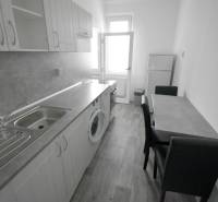 Pekný 3i byt, 3 x NEPRIECH.IZBA, BALKÓN, Radarová ulica, Ostredky - Kuchyňa v 3-izbovom byte s podlahou s dreveným dekorom, umývadlom a jedálenským stolom.