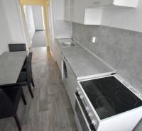 Pekný 3i byt, 3 x NEPRIECH.IZBA, BALKÓN, Radarová ulica, Ostredky - Kuchyňa 3-izbového bytu s linkou, varnou doskou a jedálenským stolom. Podlaha s dreveným dekorom.