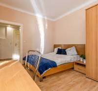 Pekná Garsónka, CENTRUM, REKONŠTRUKCIA,Vajanského nábrežie,Staré Mesto - Garsónka s podlahou s dreveným dekorom, posteľou a šatníkovou skriňou, zdobená kvetmi.