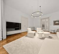  EXKLUZÍVNY, VEĽKOMETRÁŽNY 3i byt ( 130 m2 ), REKONŠTRUKCIA, CENTRUM - Obývacia izba v 3-izbovom byte s podlahou s dreveným dekorom a pohodlnými kreslami.