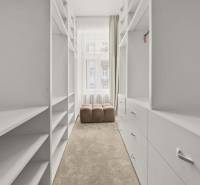  EXKLUZÍVNY, VEĽKOMETRÁŽNY 3i byt ( 130 m2 ), REKONŠTRUKCIA, CENTRUM - Úzka šatníková miestnosť s bielymi policami a béžovým kreslom v 3-izbovom byte.