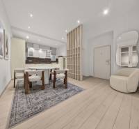  EXKLUZÍVNY, VEĽKOMETRÁŽNY 3i byt ( 130 m2 ), REKONŠTRUKCIA, CENTRUM - Interiér 3-izbového bytu s jedálenským stolom, kreslom a podlahou s dreveným dekorom.