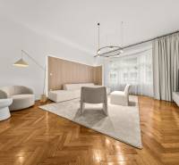  EXKLUZÍVNY, VEĽKOMETRÁŽNY 3i byt ( 130 m2 ), REKONŠTRUKCIA, CENTRUM - Obývacia izba s podlahou s dreveným dekorom, bielym nábytkom a veľkými oknami v 3-izbovom byte.