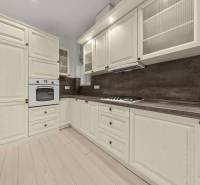  EXKLUZÍVNY, VEĽKOMETRÁŽNY 3i byt ( 130 m2 ), REKONŠTRUKCIA, CENTRUM - Kuchynská linka s bledými skrinkami a zabudovanou rúrou, podlaha s dreveným dekorom.