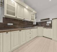  EXKLUZÍVNY, VEĽKOMETRÁŽNY 3i byt ( 130 m2 ), REKONŠTRUKCIA, CENTRUM - Kuchyňa v 3-izbovom byte s bielymi skrinkami a podlahou s dreveným dekorom.