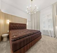  EXKLUZÍVNY, VEĽKOMETRÁŽNY 3i byt ( 130 m2 ), REKONŠTRUKCIA, CENTRUM - Spálňa v 3-izbovom byte s veľkou posteľou, textilnými závesmi a lustrom.