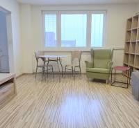 MODERNÝ 2i byt, REKONŠTRUKCIA, KLÍMA, MOZARTOVA ulica, Horský park - Obývacia izba v 2-izbovom byte s podlahou s dreveným dekorom, televíziou a policovou stenou.