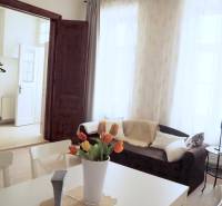 U NÁS !!! Pekný 2i byt, CENTRUM, REKONŠTRUKCIA, Klobučnícka ulica - Obývacia izba 2-izbového bytu na ulici Klobučnícka s pohodlným gaučom a kvetinovou dekoráciou.