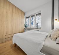 ŠTÝLOVÝ 3i byt, REKONŠTRUKCIA, Mýtna ulica, Staré Mesto - Spálňa v 3-izbovom byte s posteľou, vstavanou skriňou a podlahou s dreveným dekorom.