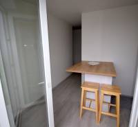 SLNEČNÝ 2i byt, REKONŠTRUKCIA, 2 X SAMOST.IZBA, BALKÓN, Haburská ulica - Balkón s barovým pultom a stoličkami v 2-izbovom byte, podlaha s dreveným dekorom.