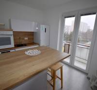 SLNEČNÝ 2i byt, REKONŠTRUKCIA, 2 X SAMOST.IZBA, BALKÓN, Haburská ulica - Kuchyňa v 2-izbovom byte s podlahou s dreveným dekorom a balkónovými dverami.