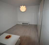 SLNEČNÝ 2i byt, REKONŠTRUKCIA, 2 X SAMOST.IZBA, BALKÓN, Haburská ulica - Obývacia izba v 2-izbovom byte s podlahou s dreveným dekorom a výrazným svietidlom.