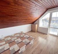 Na prenájom 3i byt v rodinom dome so záhradou - Vojenská ul. Rovinka - Podkrovný 3-izbový byt s dreveným stropom, posteľou a oknom na Vojenskej ulici.