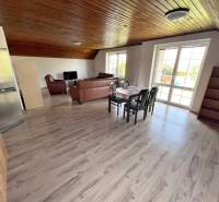 Na prenájom 3i byt v rodinom dome so záhradou - Vojenská ul. Rovinka - Svetlá obývačka 3-izbového bytu na ulici Vojenská, s dreveným stropom a podlahou.